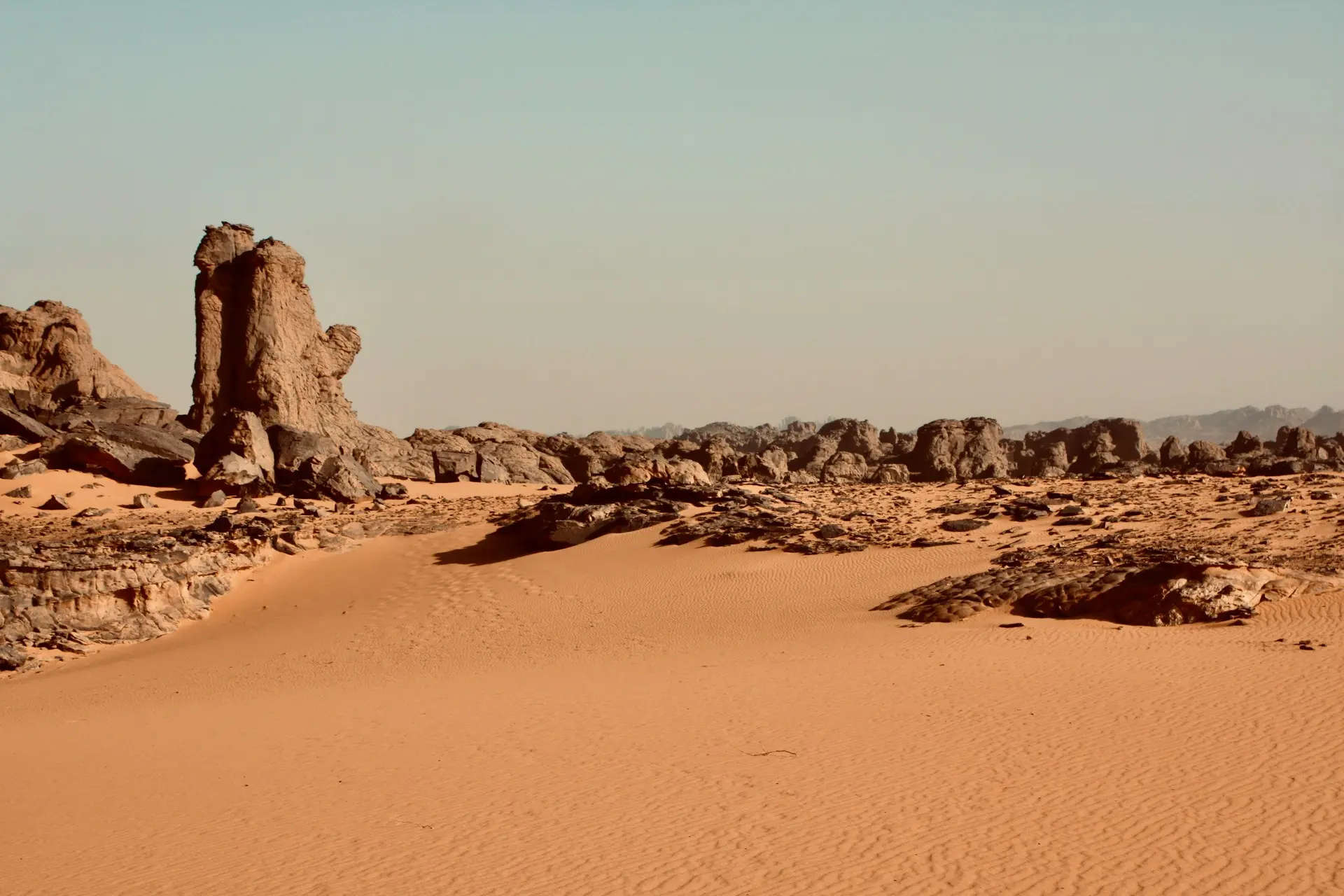 Photo of the Sahara Desert with some large rocks