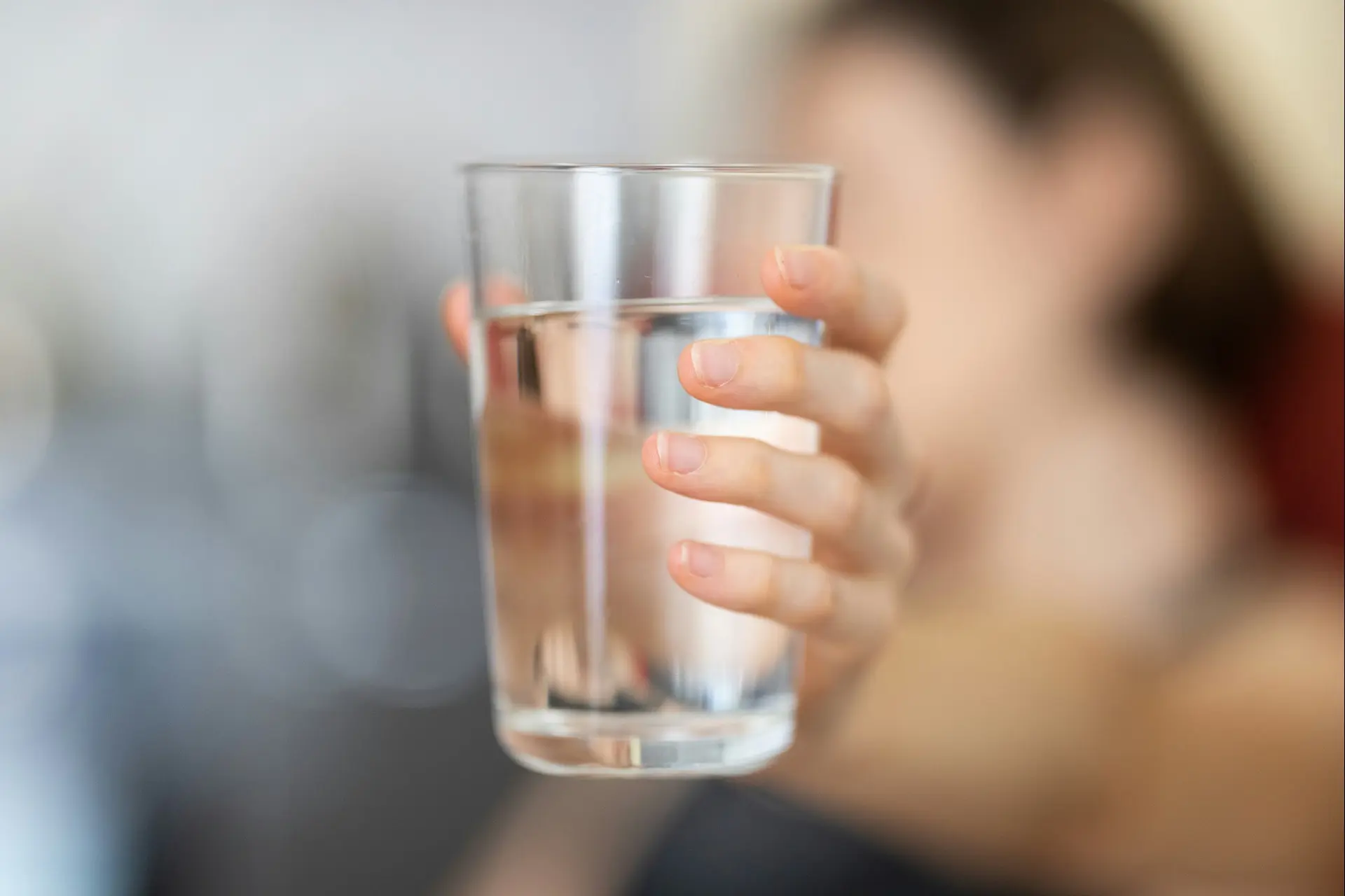photo of a hand holding a clean glass of water
