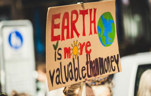 sign that says earth is more valuable than money