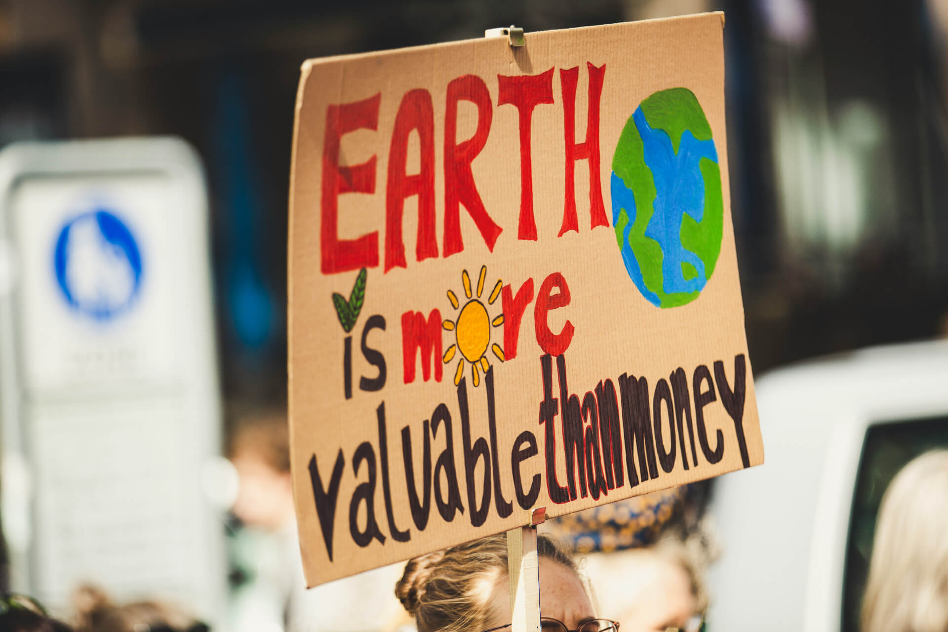 sign that says earth is more valuable than money