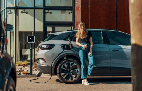 person standing next to a charging ev