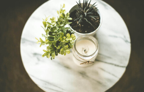 candle and succulent on marble table