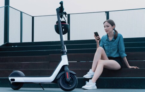 woman sitting beside her electric scooter