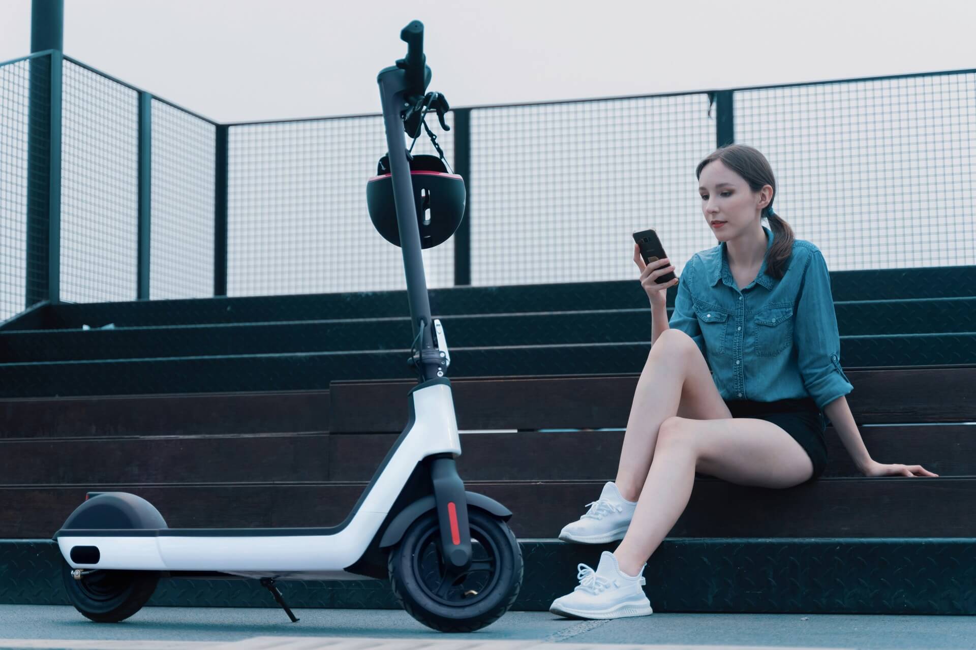 woman sitting beside her electric scooter