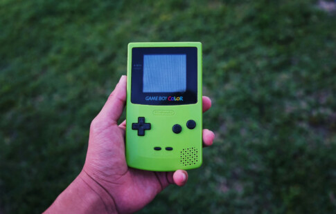 person holding a green game boy