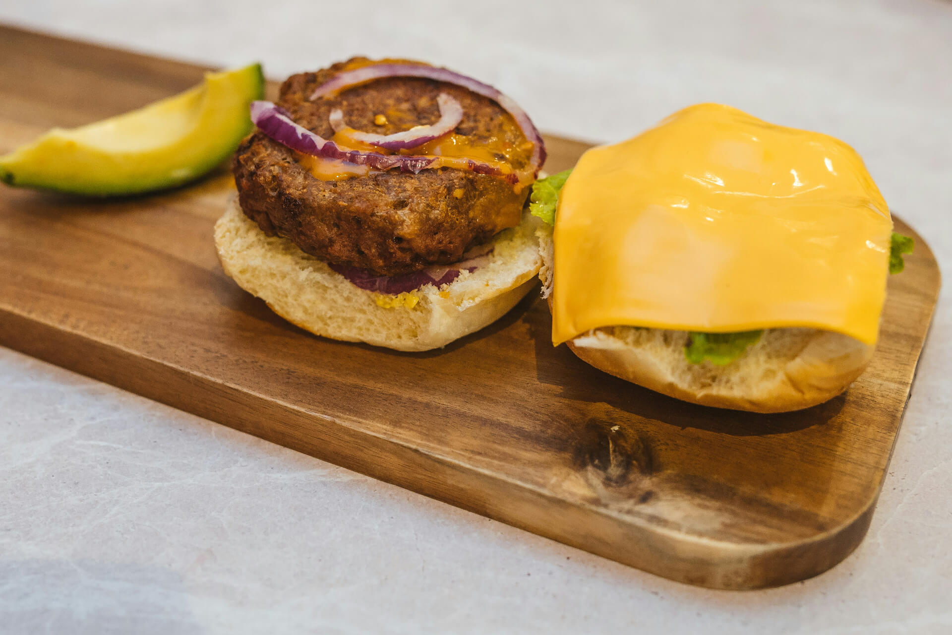 vegan burger with vegan cheese on wood board