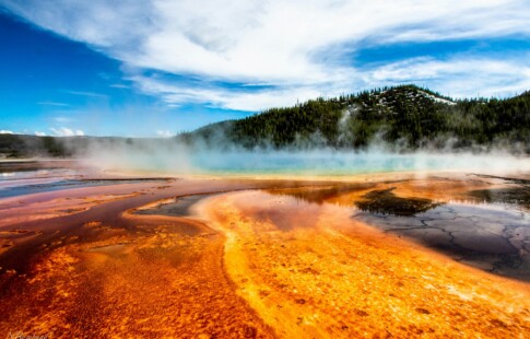 a breathtaking view of a geyser in Yellowstone amidst a blue sky