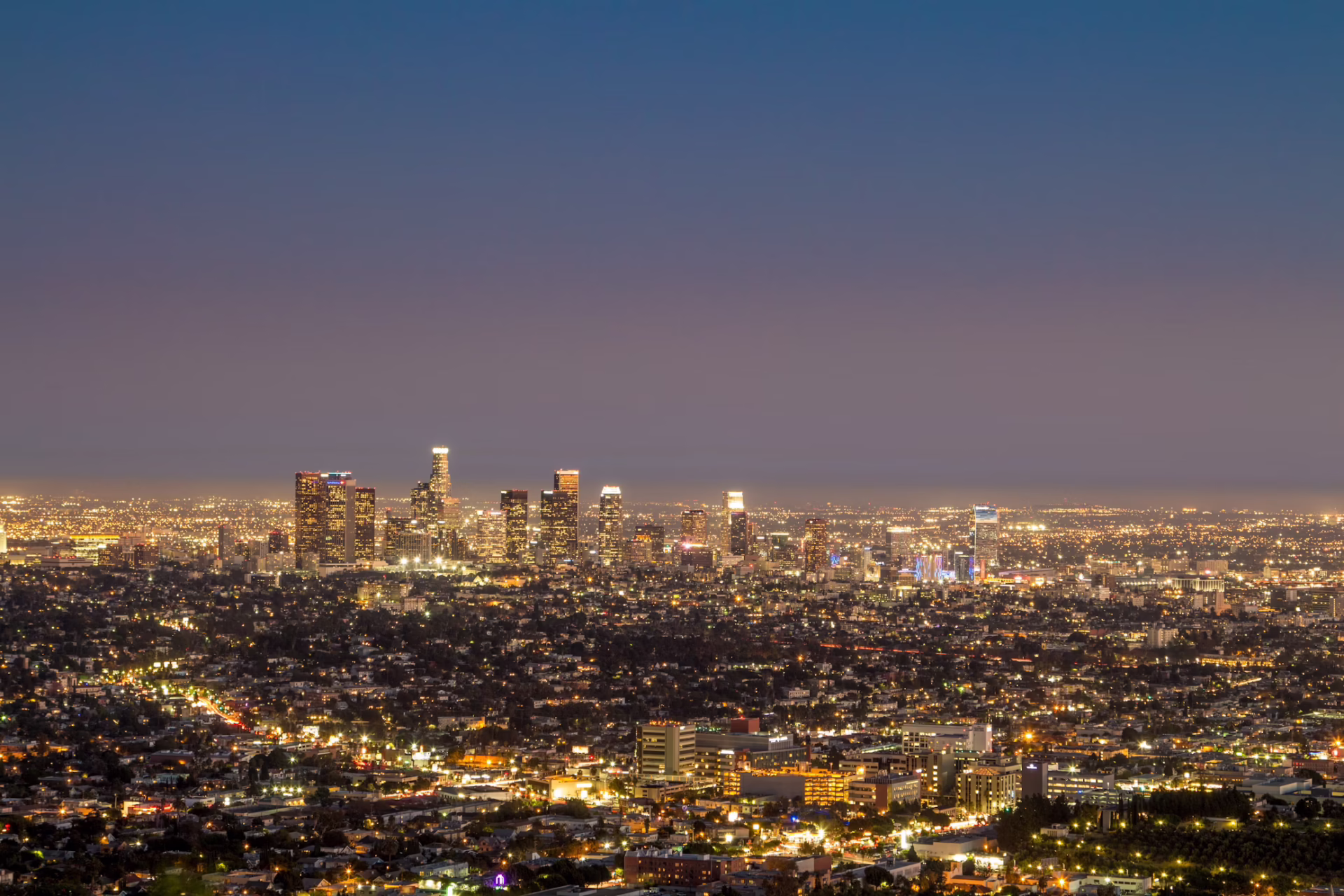 A shining city skyline at night. There are no stars in the sky.