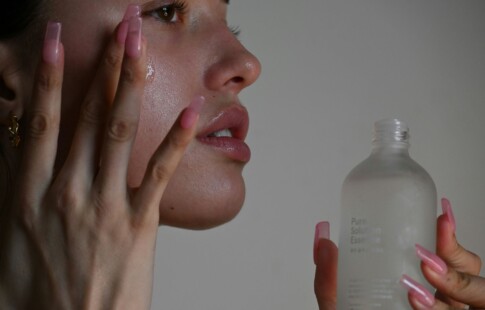 a woman applying a skincare serum to her face