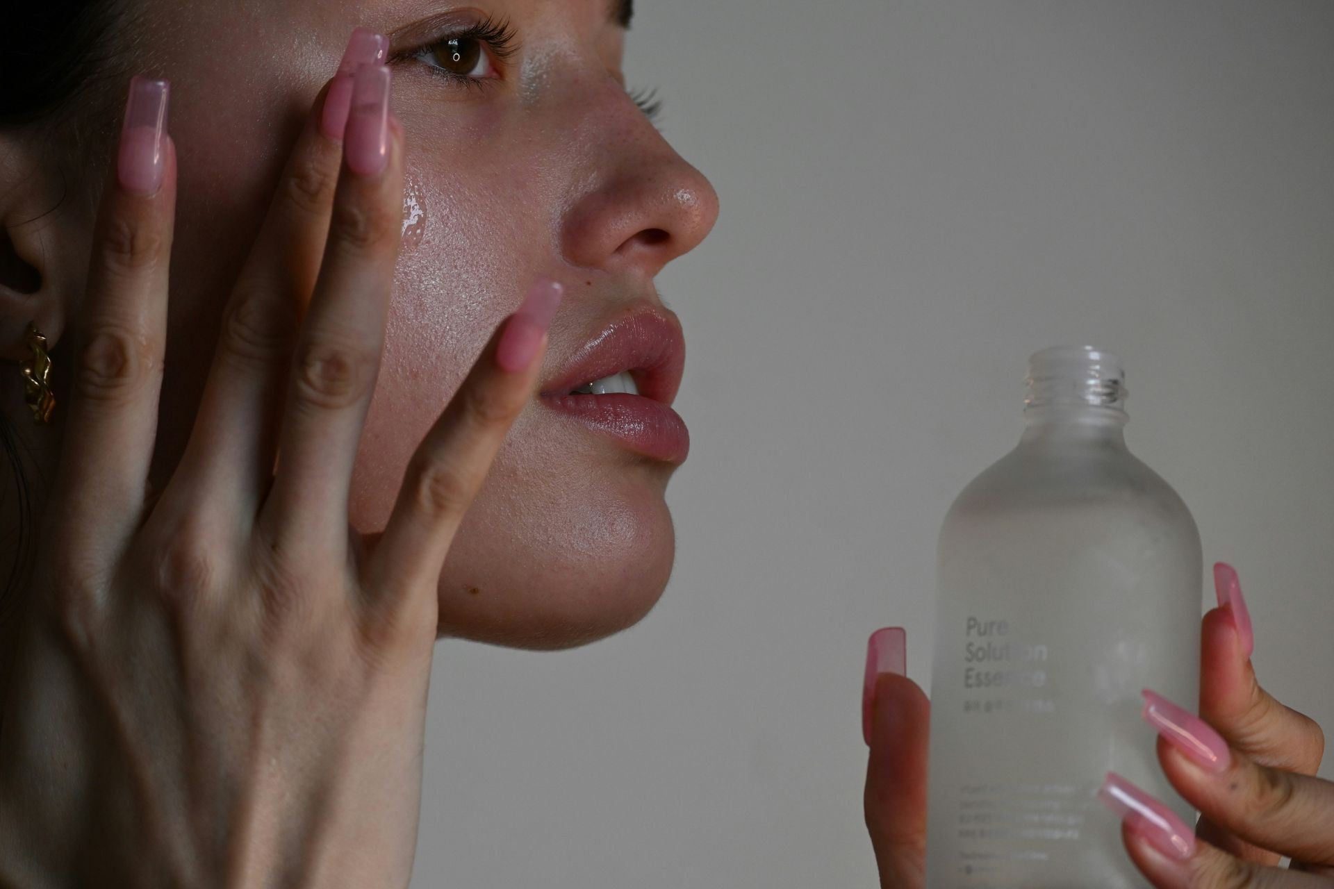 a woman applying a skincare serum to her face