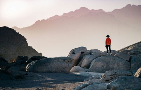 person standing on rocks overlooking horizon